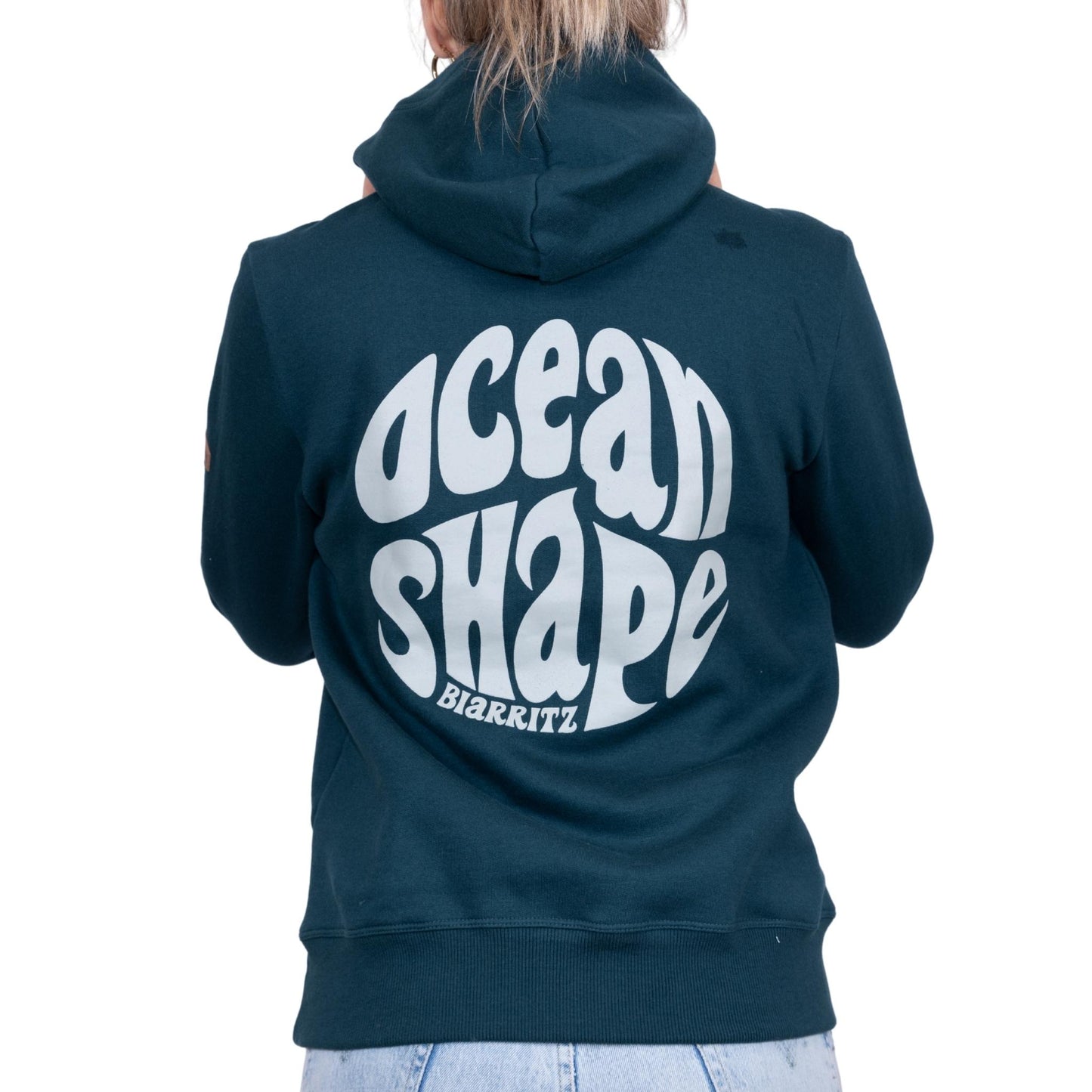 Sweat unisexe à capuche vert foncé avec grand logo bubble "Ocean Shape Biarritz" beige dans le dos, vu de dos sur mannequin femme