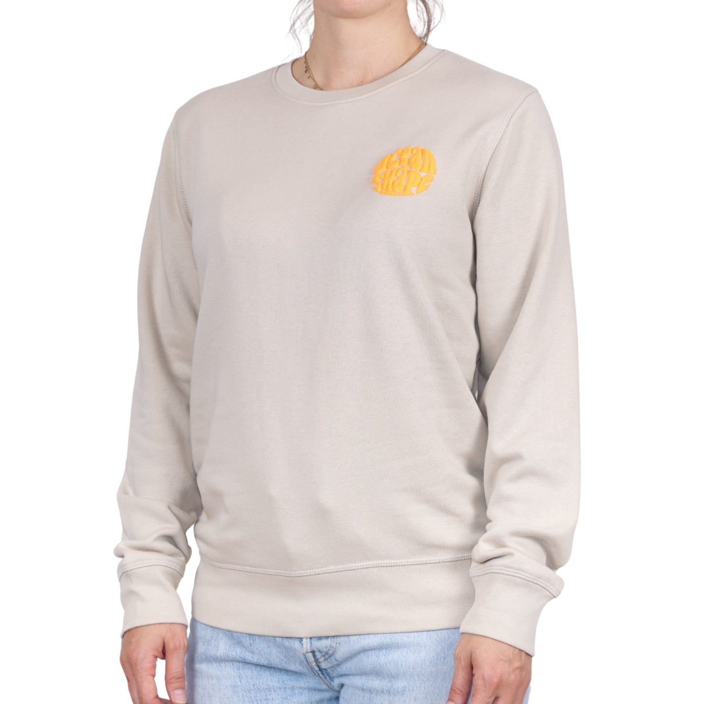 Sweat unisexe sans capuche Desert Dust avec petit logo bubble "ocean shape biarritz" orange fluo sur la poitrine, vu de face sur mannequin femme.