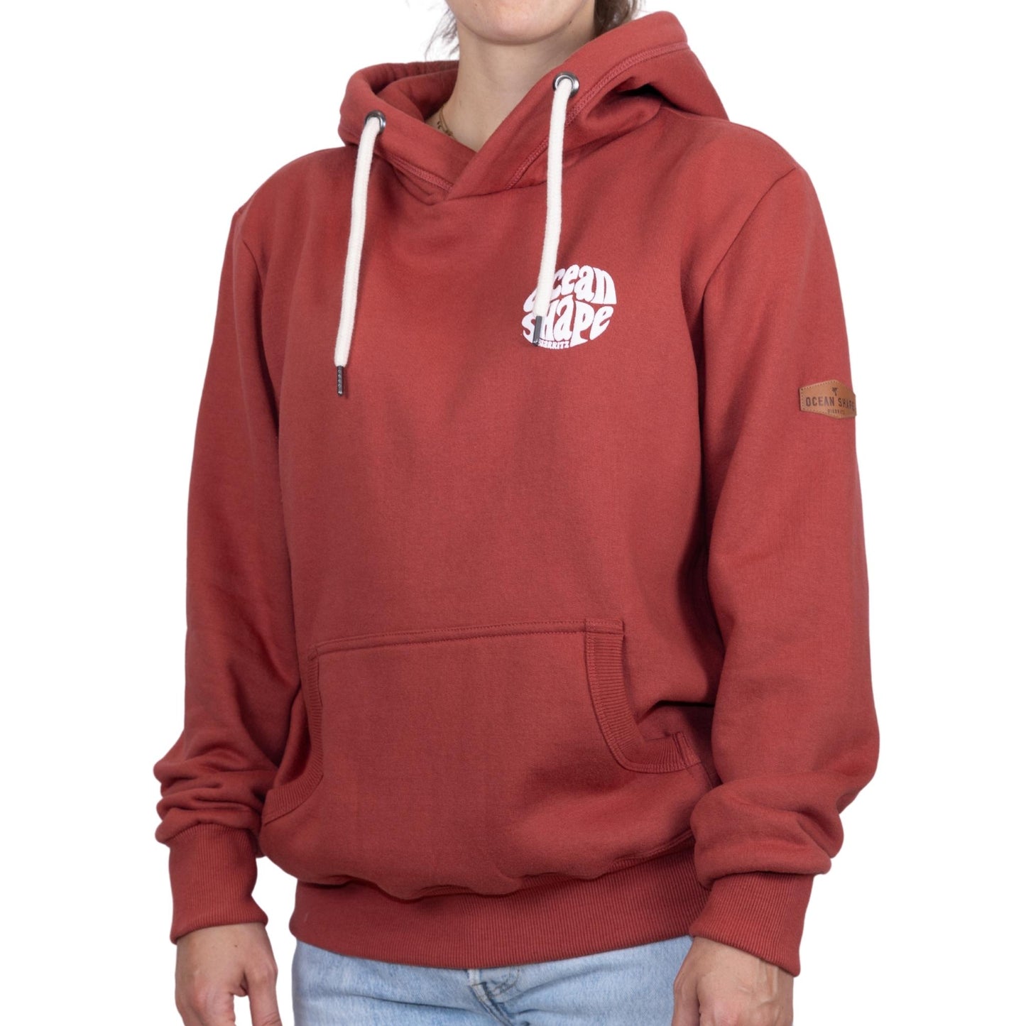 Sweat unisexe à capuche terracotta avec petit logo bubble "Ocean Shape Biarritz" sur la poitrine, vu de face sur mannequin femme