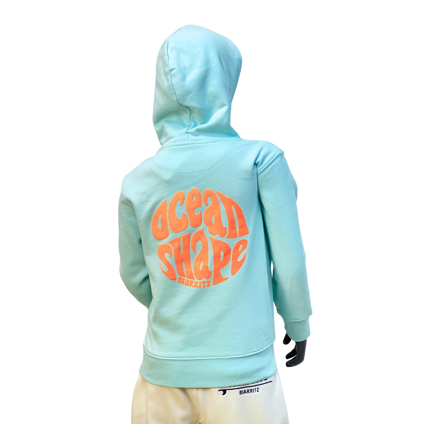 Sweat à capuche enfant, bleu ciel, avec gros logo bubble "Ocean Shape Biarritz" orange fluo dans le dos.
Vu de dos sur mannequin enfant.