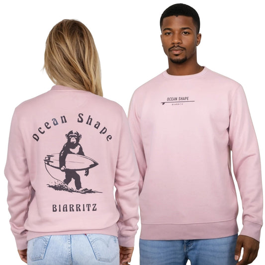 Sweat à col rond OceanShape unisexe rose pale, vu de dos sur mannequin femme et de face sur mannequin homme.
Devant : écriture "ocean shape biarritz" et une planche de surf en marron
Dos : écriture "ocean shape biarritz" et illustration d'un singe qui porte sa planche de surf en marron.
Style casual et surf, inspiré de la côte basque.