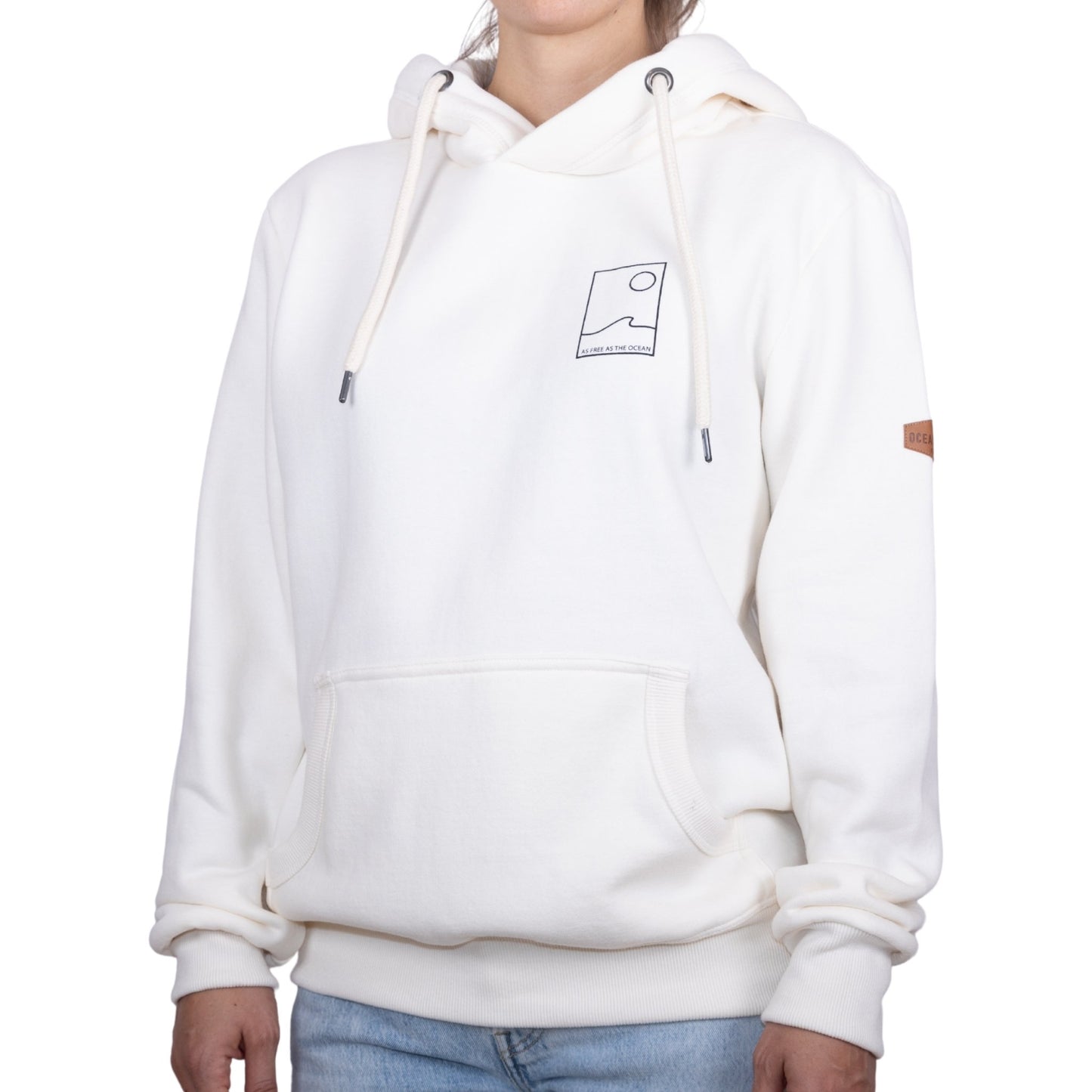 Sweat unisexe à capuche écru avec petit encadré vague / soleil minimaliste + écriture "free as ocean" noir sur la poitrine, vu de face sur mannequin femme