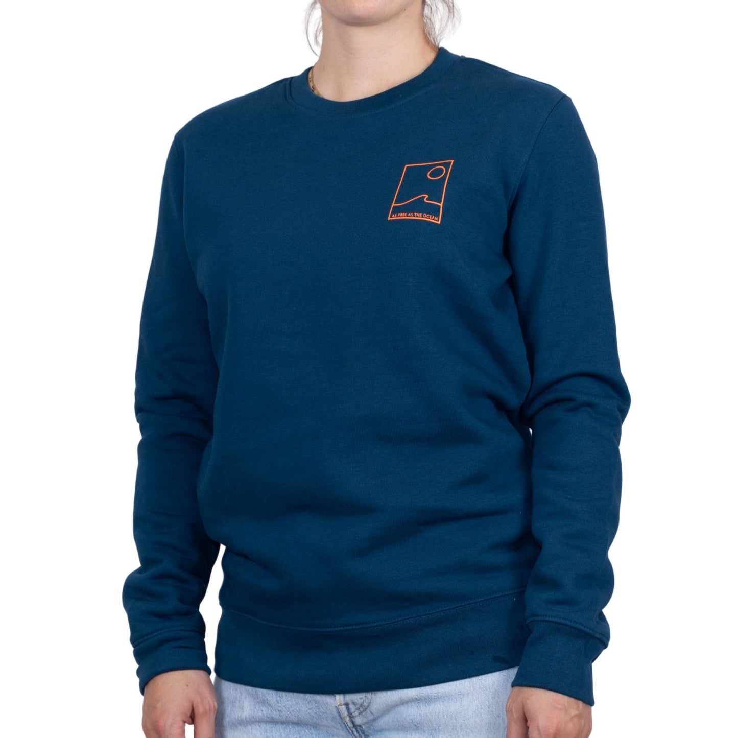 sweat unisexe bleu petrole en coton biologique avec petit encadré vague / soleil minimaliste + écriture "free as ocean" orange fluo sur la poitrine, vu de face sur mannequin femme.