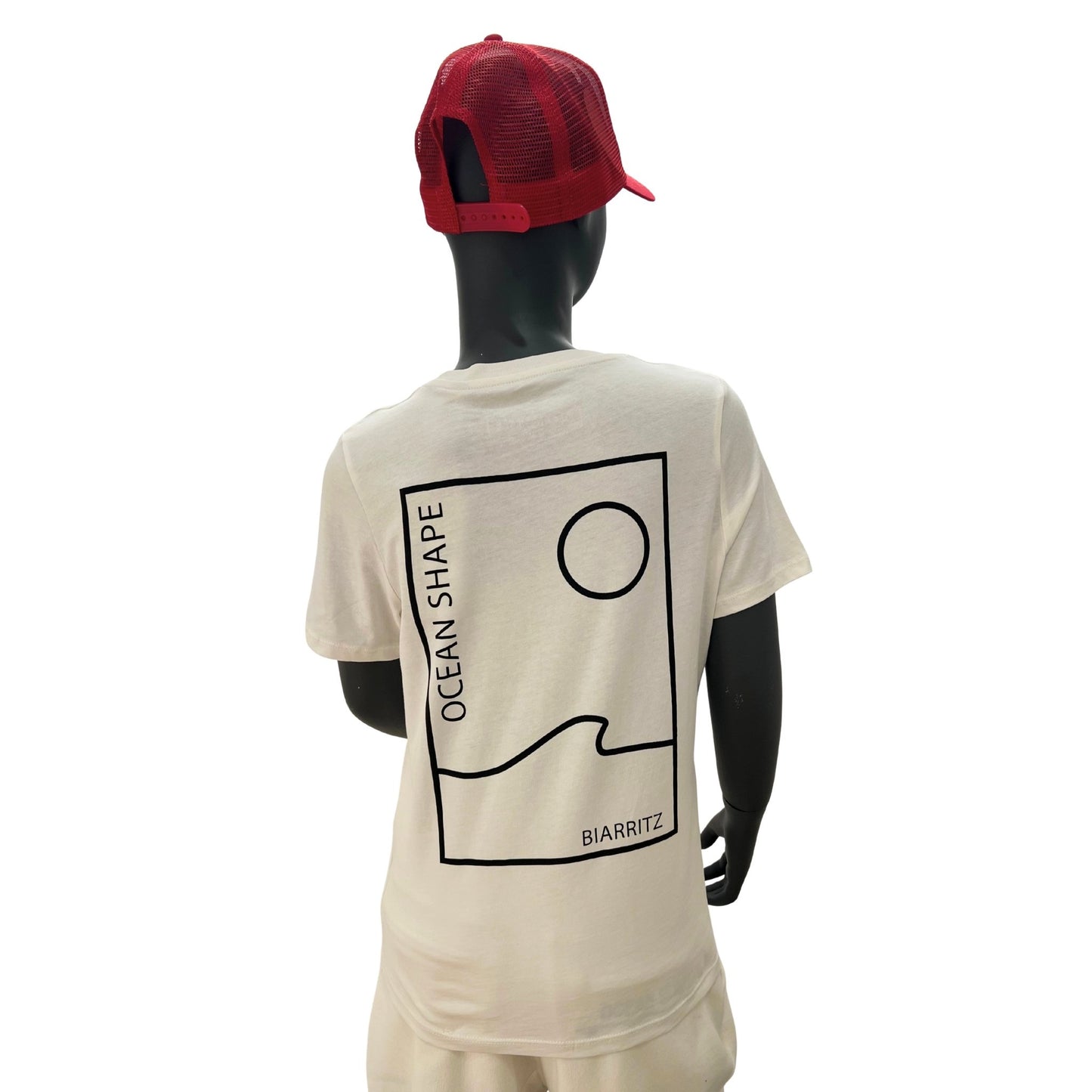 t shirt à manches courtes enfant unisexe couleur ivory, en coton biologique, sur un mannequin enfant de face et de dos.
Dos : grand dessin minimaliste d'une vague et d'un soleil avec écrit "ocean shape biarritz" noir.
