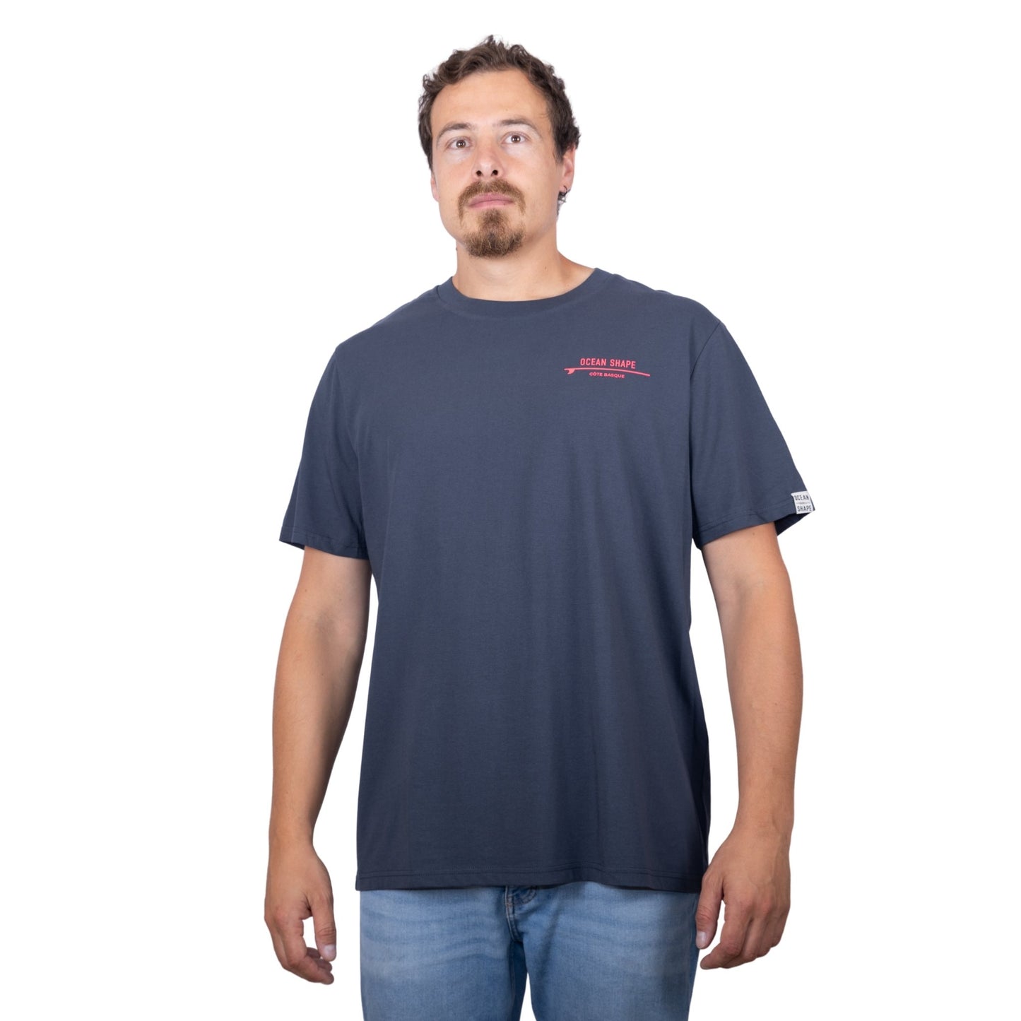 Tee-shirt unisexe gris foncé en coton biologique avec petite écriture "ocean shape" rose fluo sur la poitrine, vu de face sur mannequin homme
