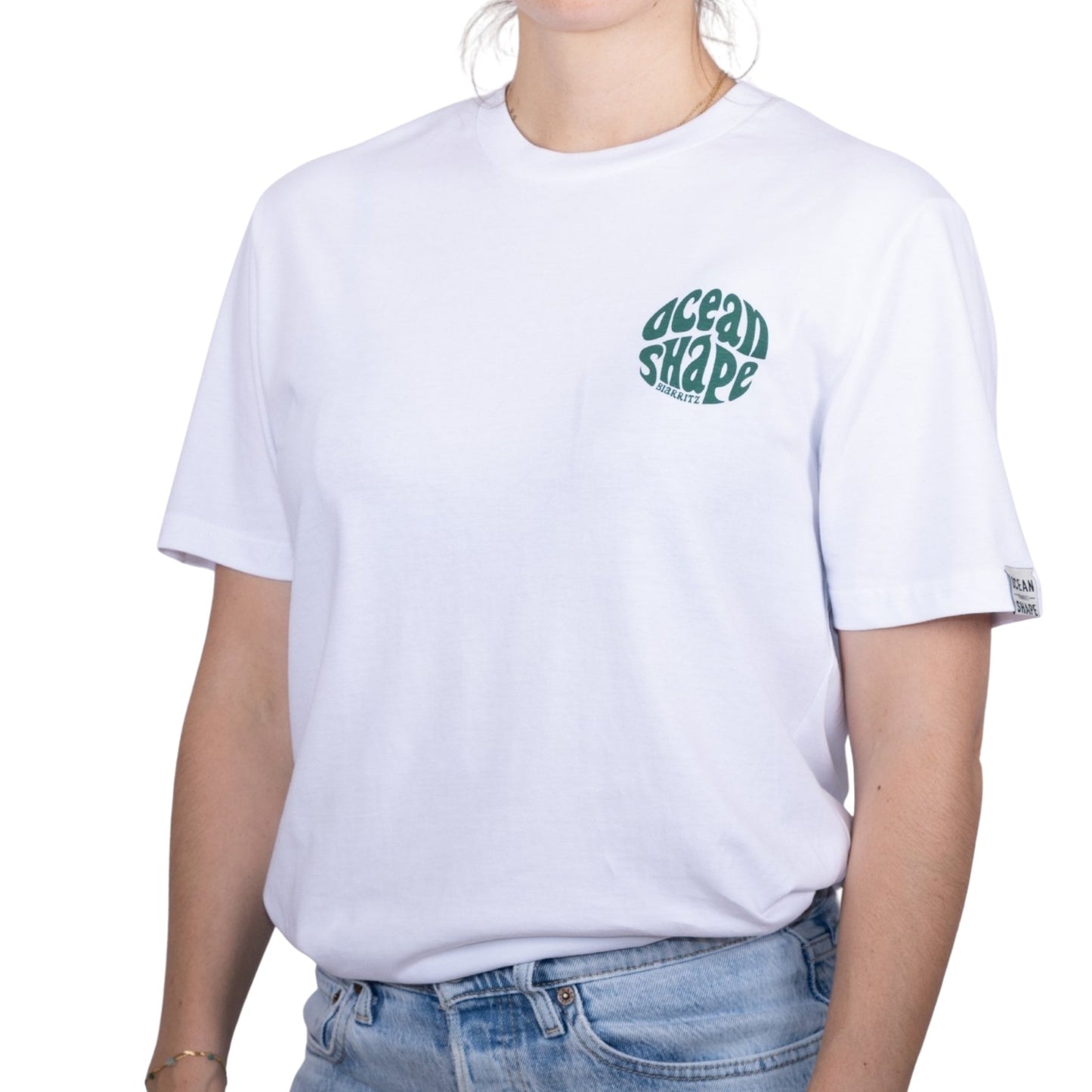 Tee-shirt unisexe blanc en coton biologique avec petit logo bubble ocean shape Biarritz vert sur la poitrine, vu de face sur mannequin femme