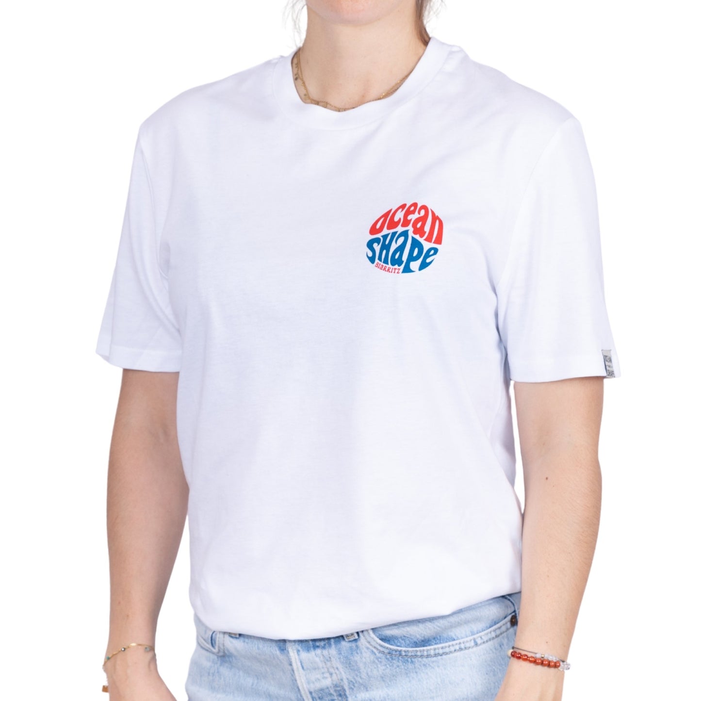 Tee-shirt unisexe blanc en coton biologique avec petit logo bubble ocean shape Biarritz rouge et bleu sur la poitrine, vu de face sur mannequin femme
