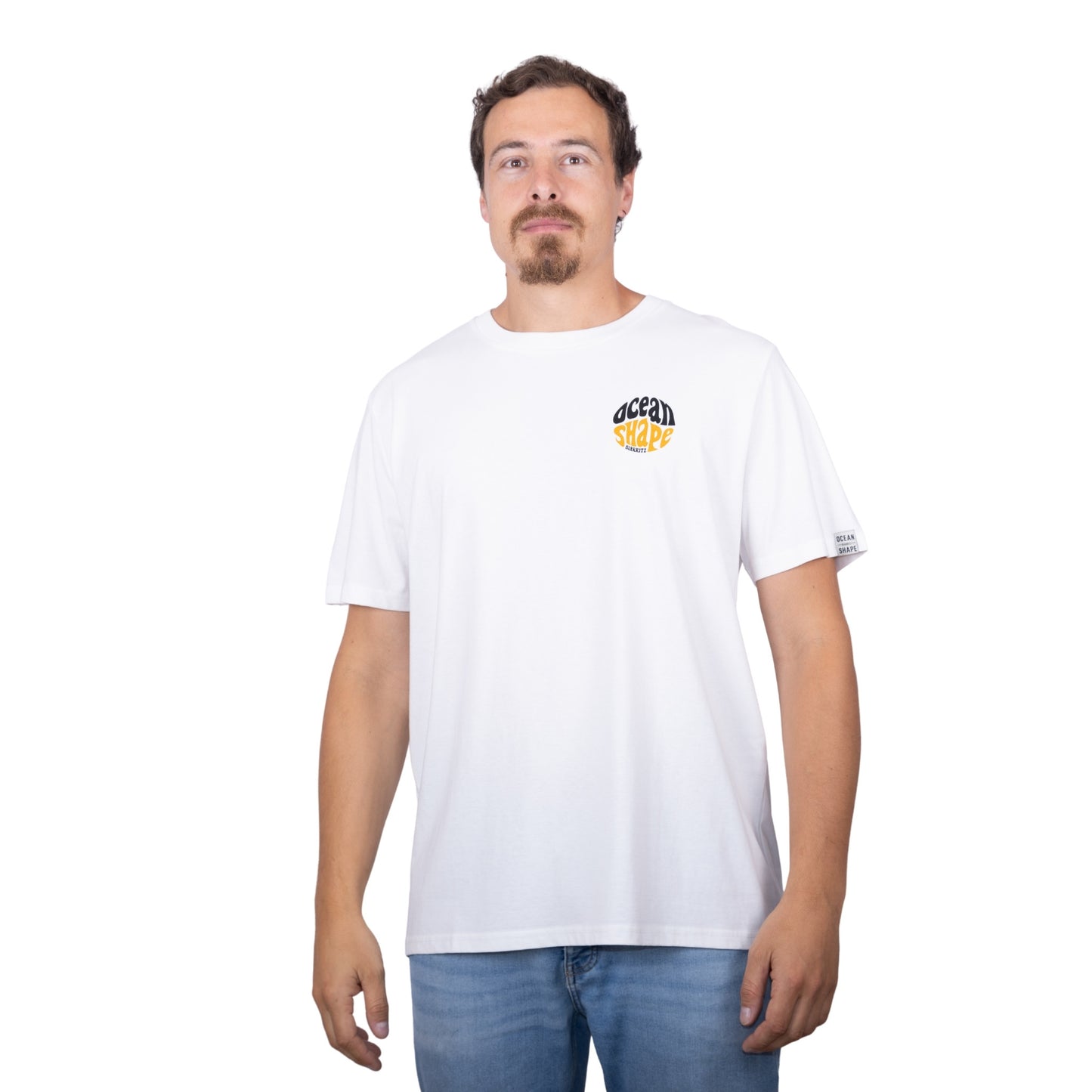 Tee-shirt unisexe blanc en coton biologique avec petit logo ocean shape Biarritz bubble noir et moutarde sur la poitrine, vu de face sur mannequin homme