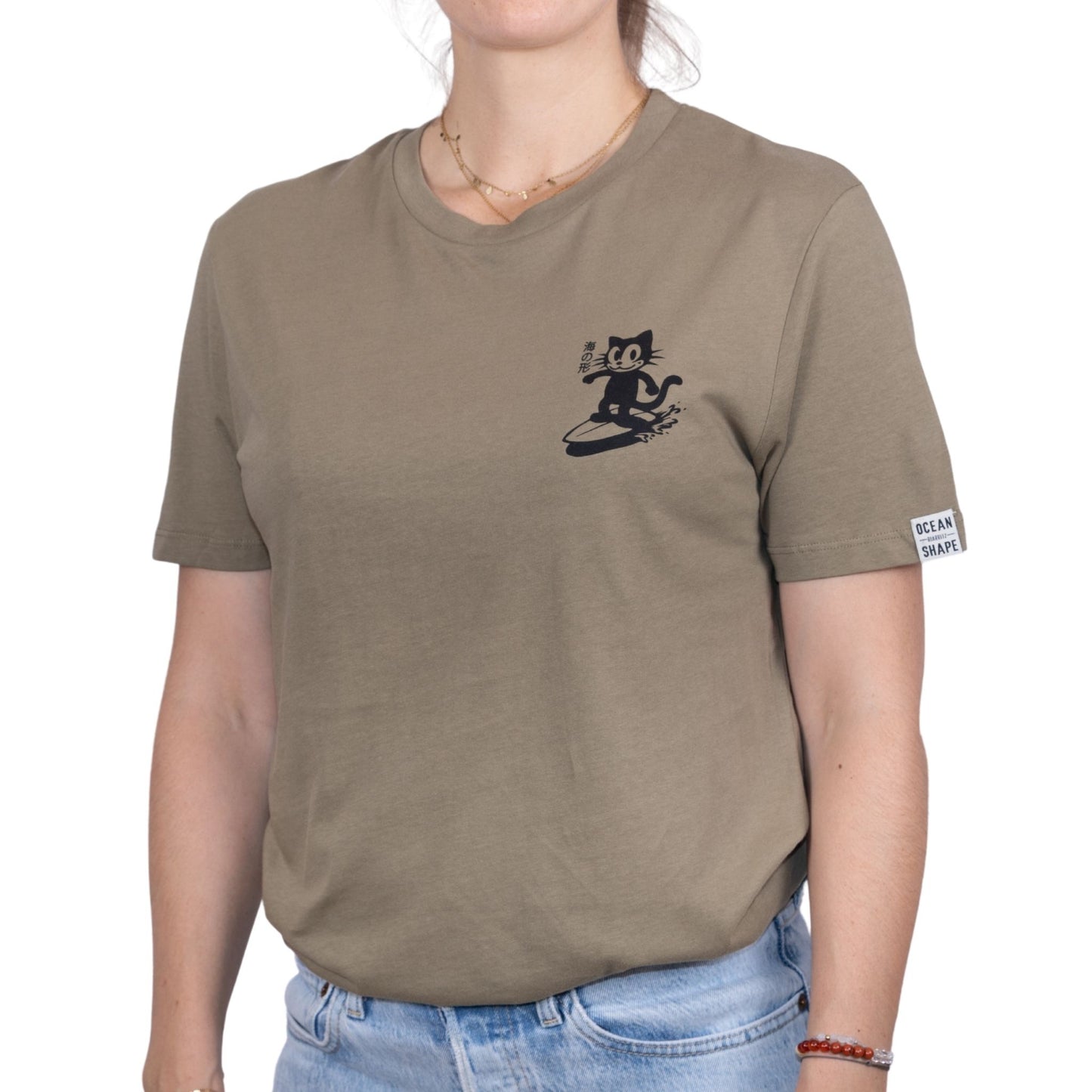 Tee-shirt unisexe light olive green en coton biologique avec petit logo chat qui surf noir sur la poitrine, vu de face sur mannequin femme