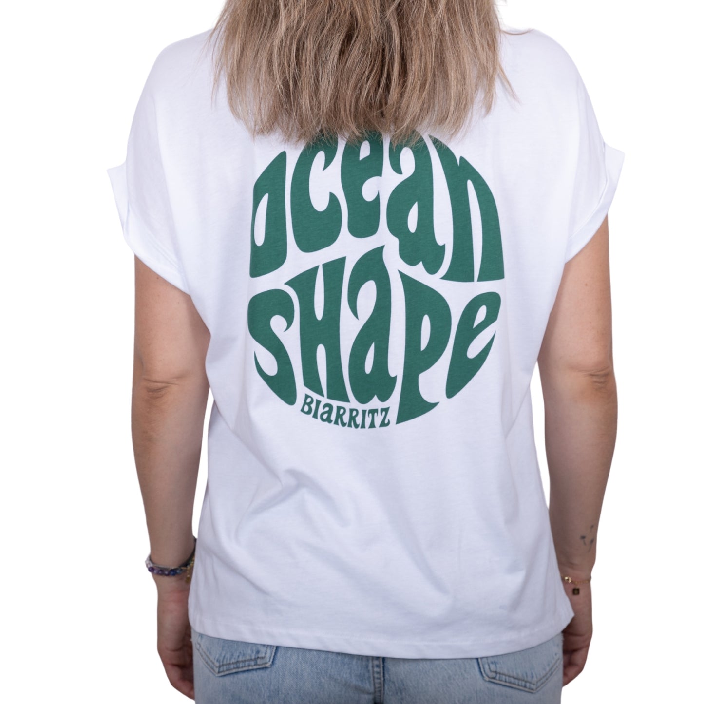 Tee-shirt femme en coton biologique blanc avec gros logo bubble "ocean shape Biarritz" vert en haut du dos, vu de dos sur mannequin femme