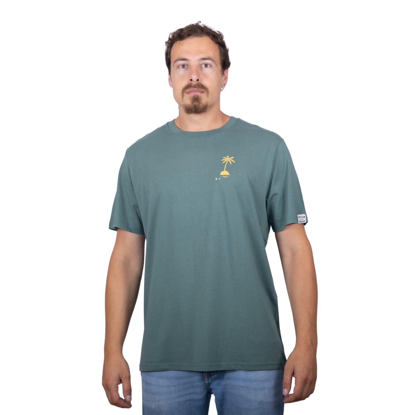 T-shirt unisexe vert sauge en coton biologique avec petit dessin palmier sur île jaune sur la poitrine, vu de face sur mannequin homme