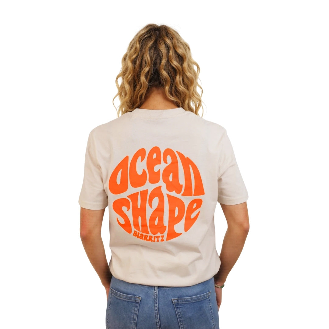 Tee-shirt en coton biologique écru.
Gros logo bubble "ocean shape biarritz" orange fluo dans le dos.
Vu de dos sur mannequin femme.
