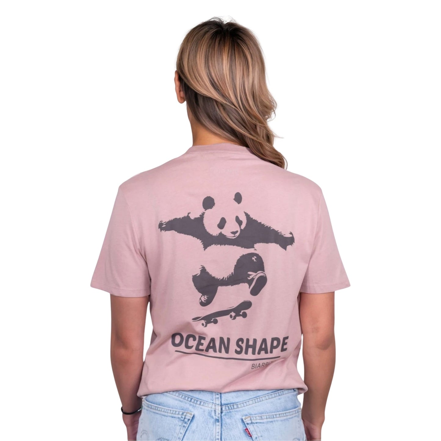 T-shirt unisexe rose pale en coton biologique avec gros dessin de panda skateur et écriture « ocean shape Biarritz » marron foncé dans le dos, vue de dos sur mannequin femme.