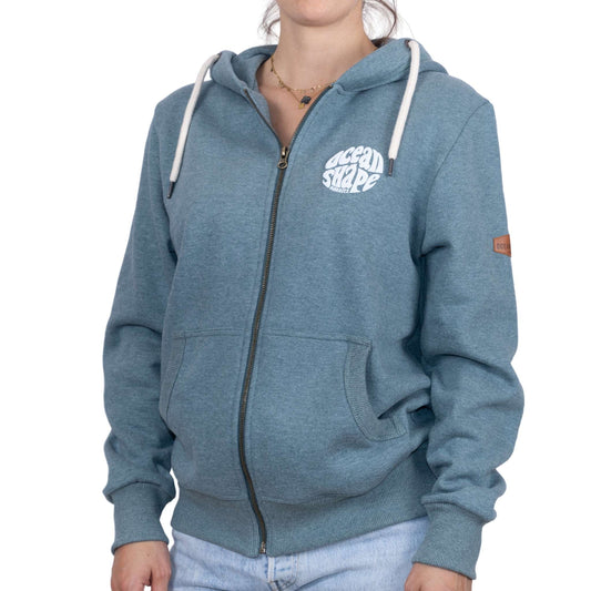 Sweat unisexe zippé à capuche vert emeraude avec petit logo bubble "Ocean Shape Biarritz" ecru sur la poitrine, vu de face sur mannequin femme