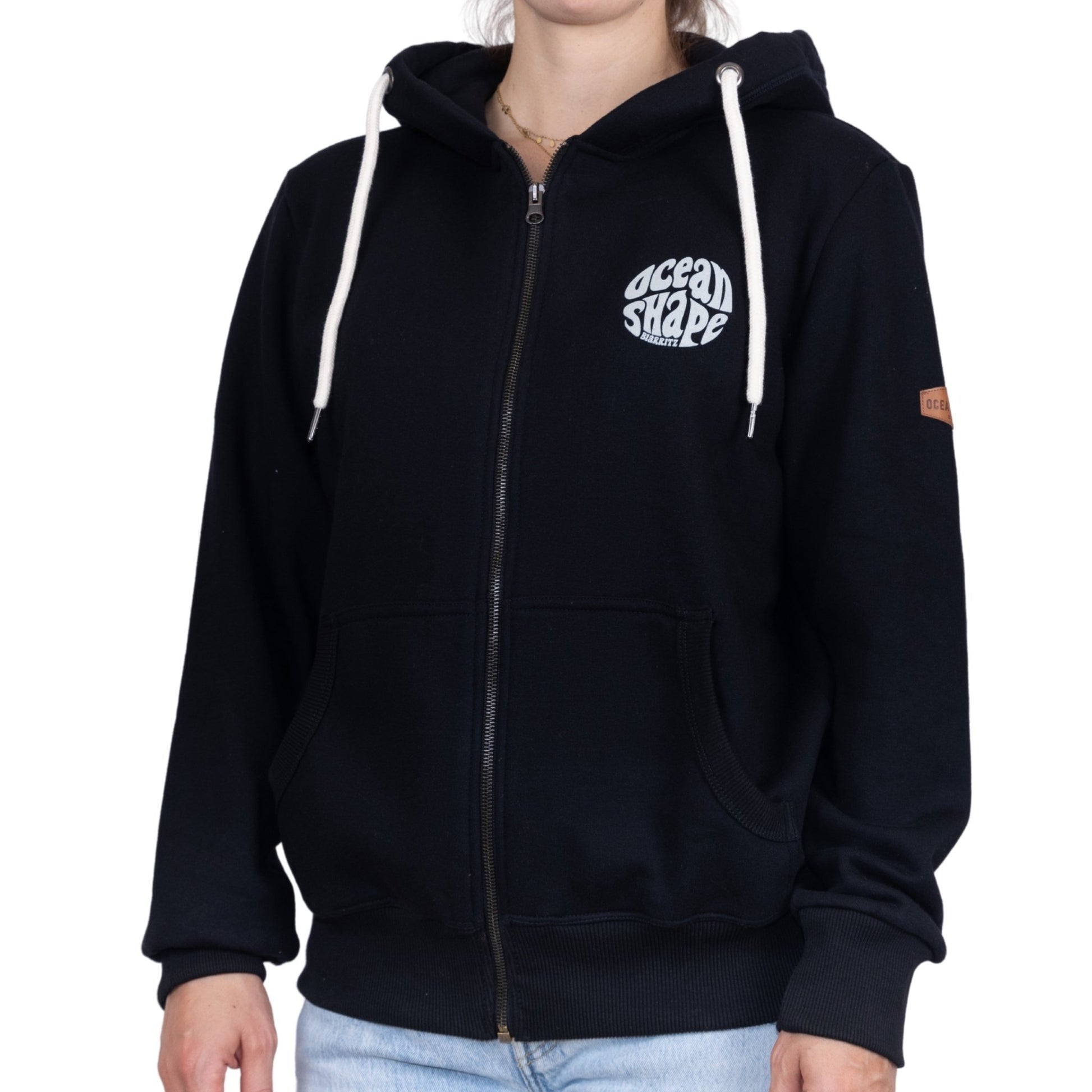 Sweat unisexe zippé à capuche noir avec petit logo bubble "Ocean Shape Biarritz" blanc sur la poitrine, vu de face sur mannequin femme