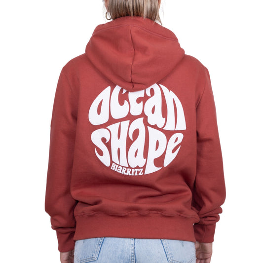 Sweat unisexe à capuche terracotta avec gros logo bubble "Ocean Shape Biarritz" blanc dans le dos, vu de dos sur mannequin femme