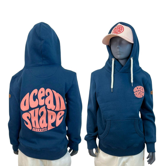 Sweat enfant à capuche bleu paon en coton biologique.
Devant : petit logo bubble "ocean shape biarritz" en encre gonflante corail sur la poitrine gauche.
Dos : gros logo bubble "ocean shape biarritz" en encre gonflante corail.
Vu de dos et de face sur mannequin enfant. 