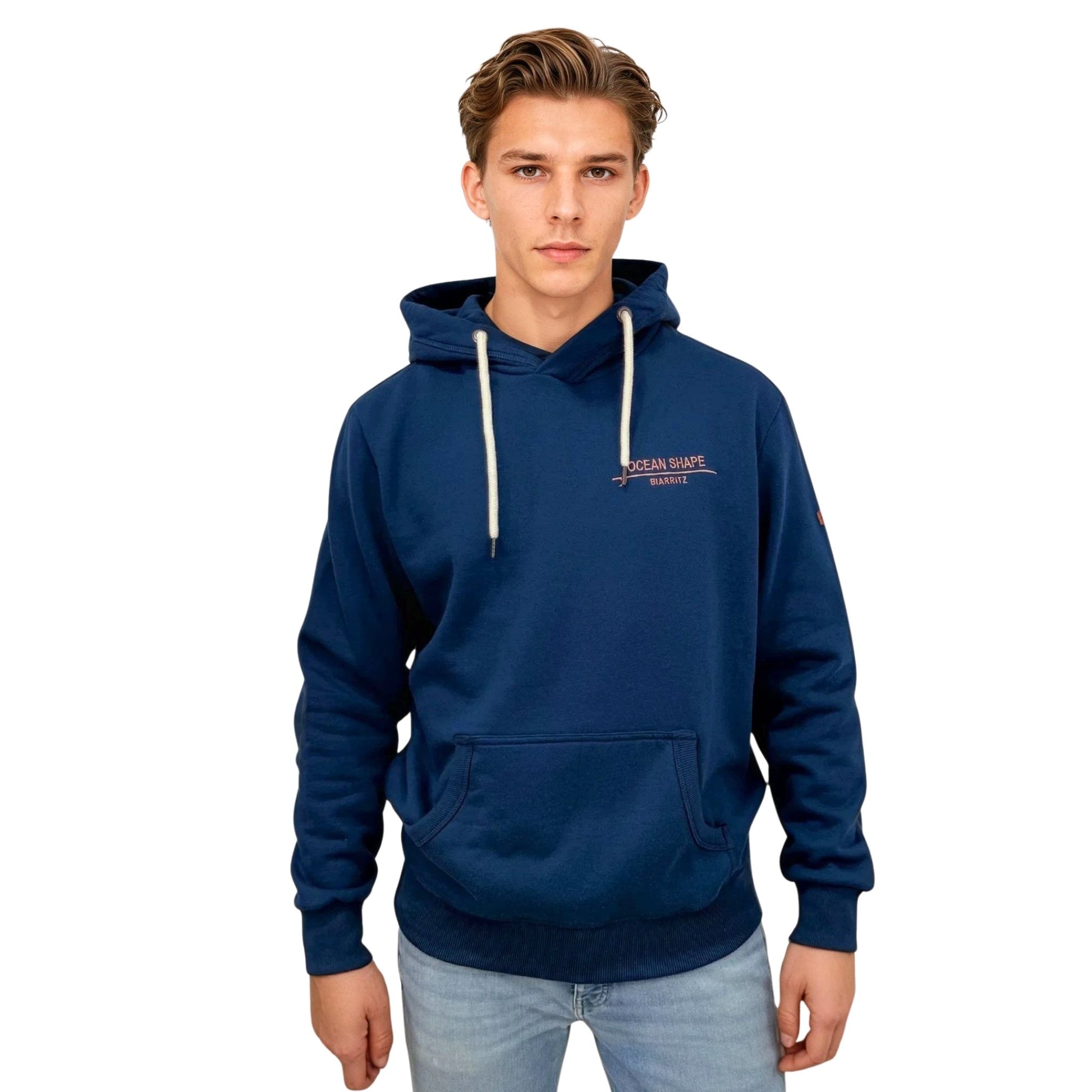 Sweat à capuche unisexe OceanShape couleur bleu paon, porté par un homme de face.
A l'avant, inscription "OceanShape" avec la mention "Biarritz" brodé en rose, et en majuscule.
Style casual et surf, inspiré de la côte basque.