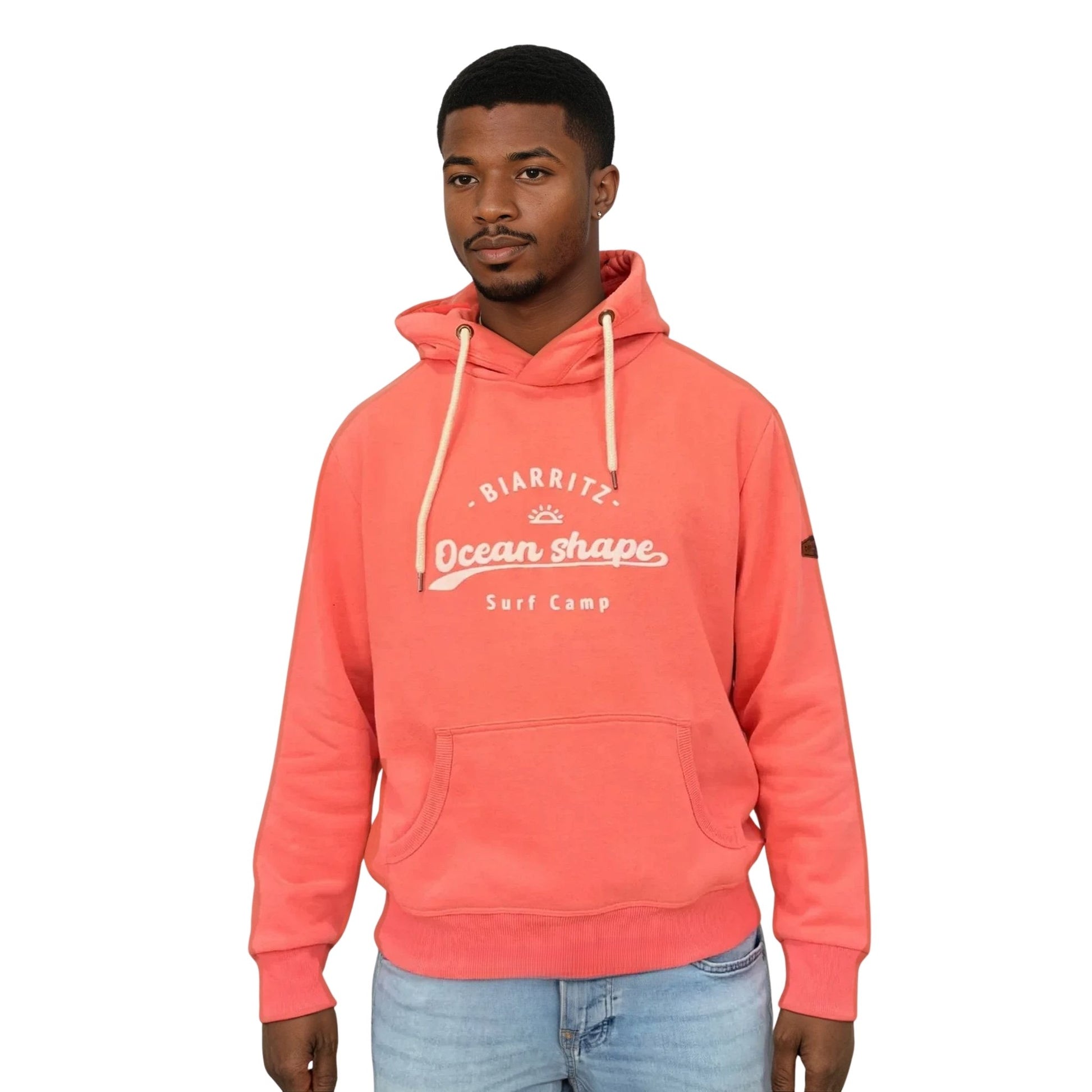 sweat à capuche ocean shape en coton biologique corail avec écriture "biarritz, ocean shape, surf camp" en encre gonflante blanche sur la poitrine, vu de face sur mannequin homme