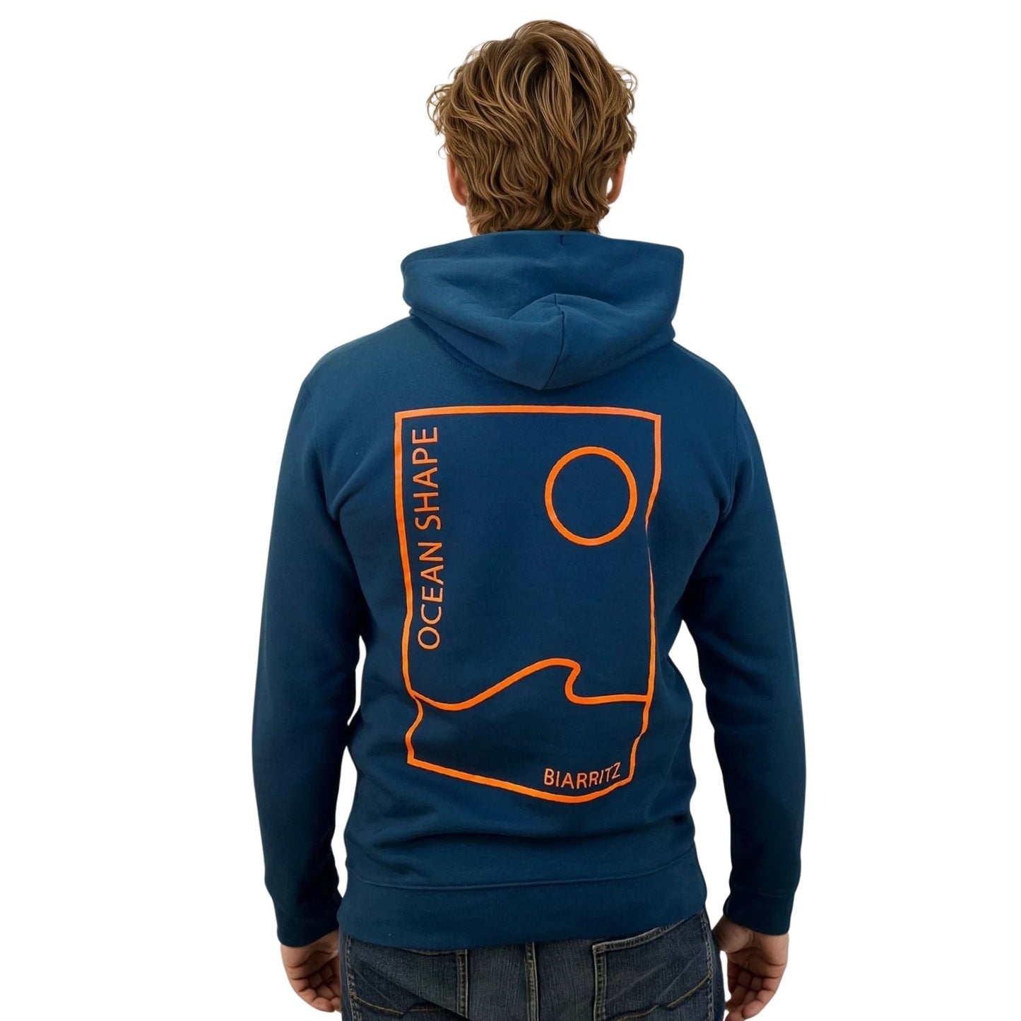 Sweat unisexe à capuche peacock blue avec petit encadré vague / soleil minimaliste + écriture "free as ocean" orange fluo sur la poitrine, vu de face sur mannequin homme