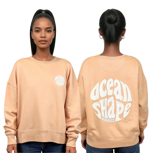Sweat femme court et oversize, col rond, épaules tombantes, 100 % coton biologique, couleur pêche.
Devant : petit logo bubble "Ocean shape Biarritz" blanc sur la poitrine gauche.
Dos : gros logo bubble "Ocean shape Biarritz" blanc.
Vu de face et de dos sur mannequin femme.