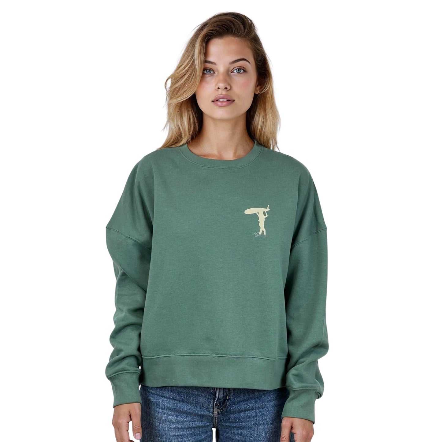 Sweat femme court et oversize, col rond, épaules tombantes, 100 % coton biologique, couleur vert sauge.
Petit dessin beige de surfeuse qui marche avec sa planche sur la tête sur la poitrine gauche.
Vu de face sur mannequin femme.