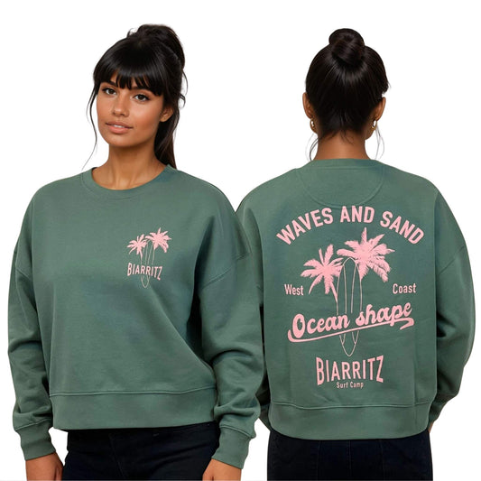 Sweat femme court et oversize, col rond, épaules tombantes, 100 % coton biologique, couleur vert sauge.
Devant : petit dessin rose pâle de planche de surf et palmiers + écriture "Biarritz" sur la poitrine gauche.
Dos : grand dessin rose pâle de planche de surf et palmiers + écriture "Waves and sand, Ocean Shape Biarritz".
Vu de face et de dos sur mannequin femme.