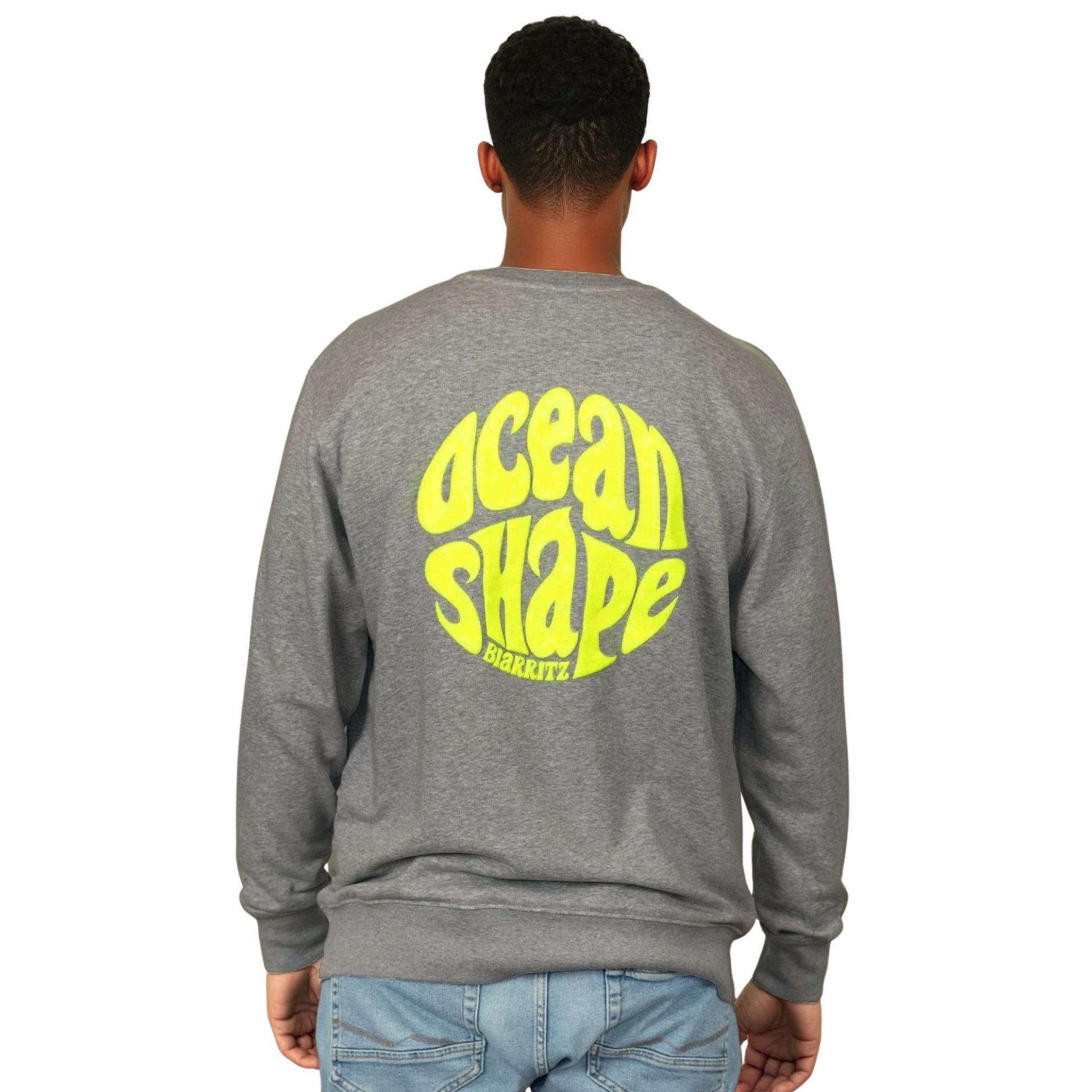 Sweat unisexe sans capuche gris anthracite avec grand logo bubble "ocean shape biarritz" jaune dans le dos, vu de dos sur mannequin homme.