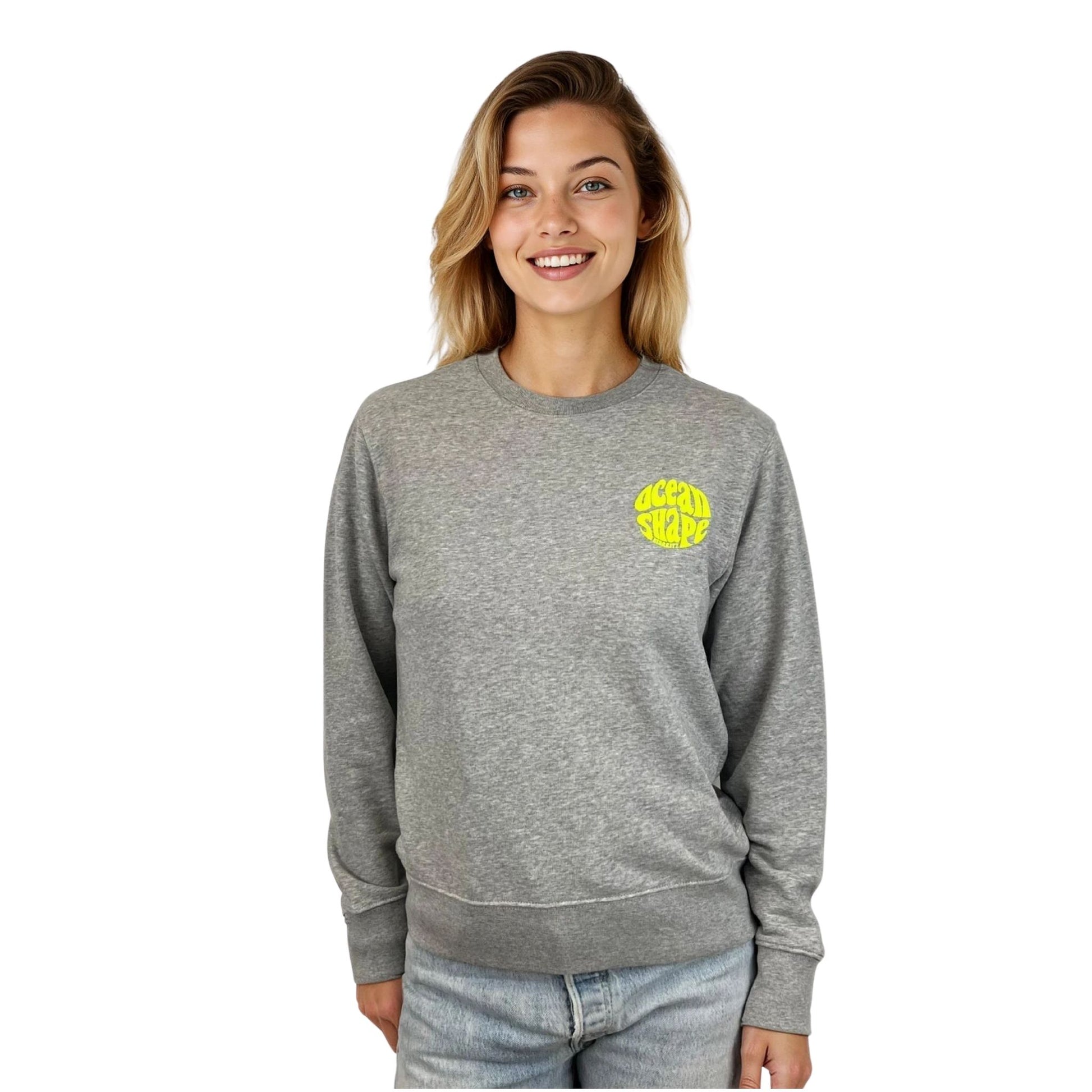 Sweat à col rond unisexe gris ocean shape, vu de face sur mannequin femme.
Devant : petit logo bubble "ocean shape biarritz" jaune fluo sur la poitrine gauche.
