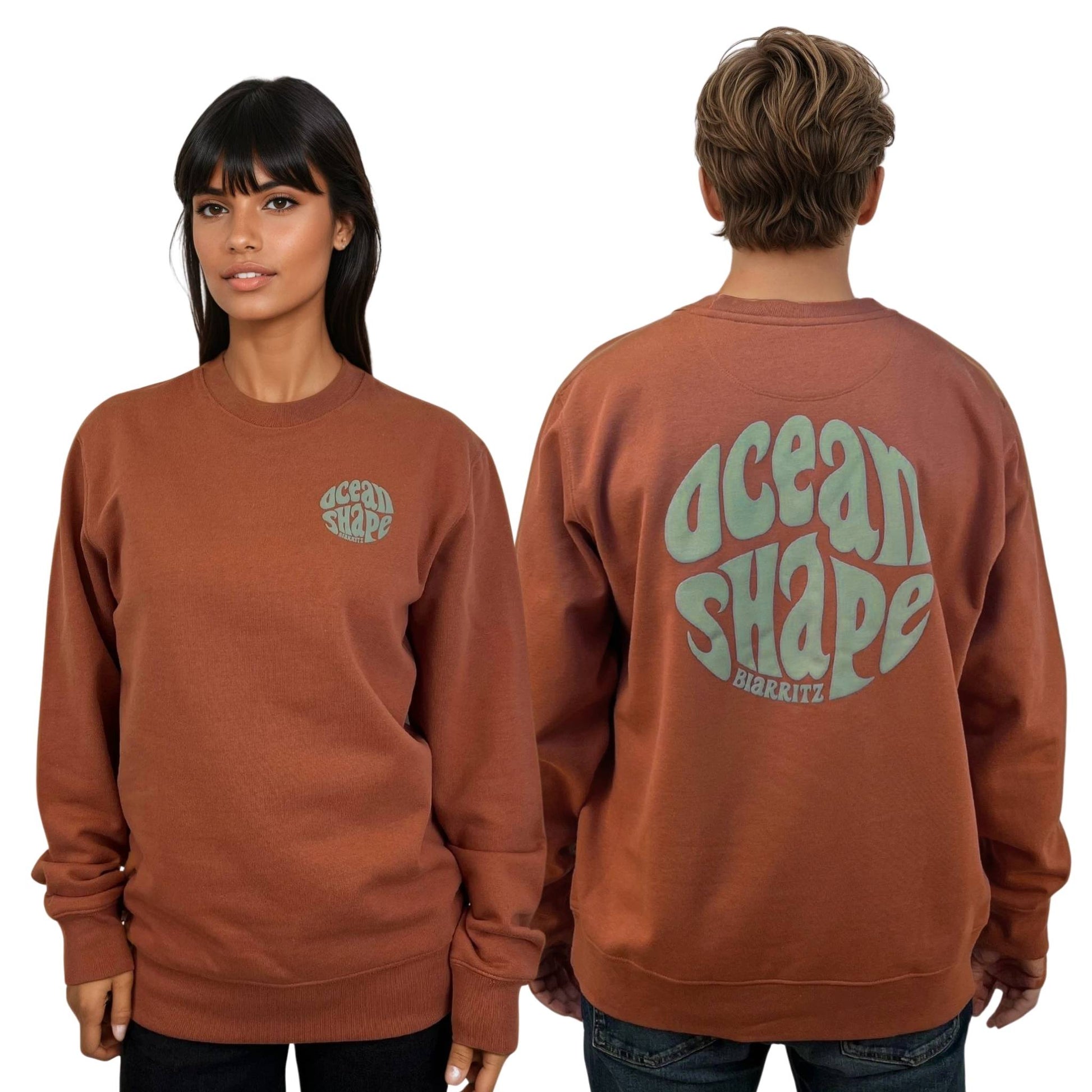 Sweat à col rond unisexe heritage brown, vu de face sur mannequin femme et de dos sur mannequin homme.
Devant : petit logo bubble "ocean shape biarritz" sauge sur la poitrine gauche.
Dos ; gros logo bubble "ocean shape biarritz" sauge