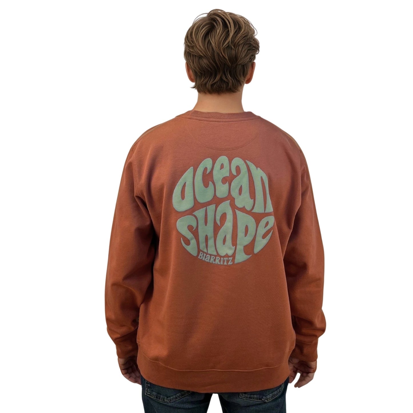 Sweat à col rond unisexe couleur sauge en coton biologique, vu de dos sur mannequin homme.
Dos ; gros logo bubble "ocean shape biarritz" couleur sauge.