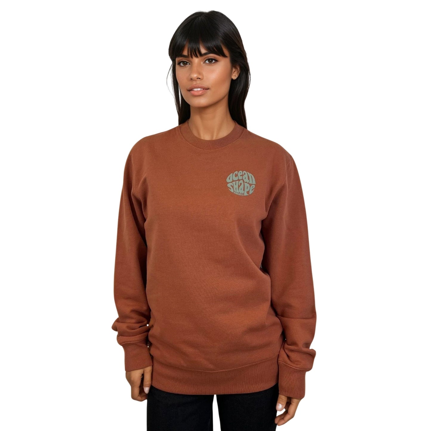 Sweat à col rond unisexe ocean shape de couleur sauge, vu de face sur mannequin femme.
Devant : petit logo bubble "ocean shape biarritz" sauge sur la poitrine gauche.