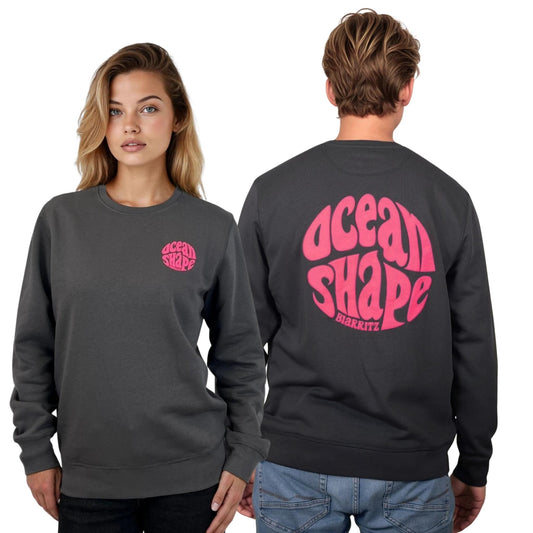 Sweat à cold round unisexe anthracite, vu de face sur mannequin femme et de dos sur mannequin homme.
Devant : petit logo bubble "ocean shape biarritz" rose fluo sur la poitrine gauche.
Dos ; gros logo bubble "ocean shape biarritz" rose fluo.