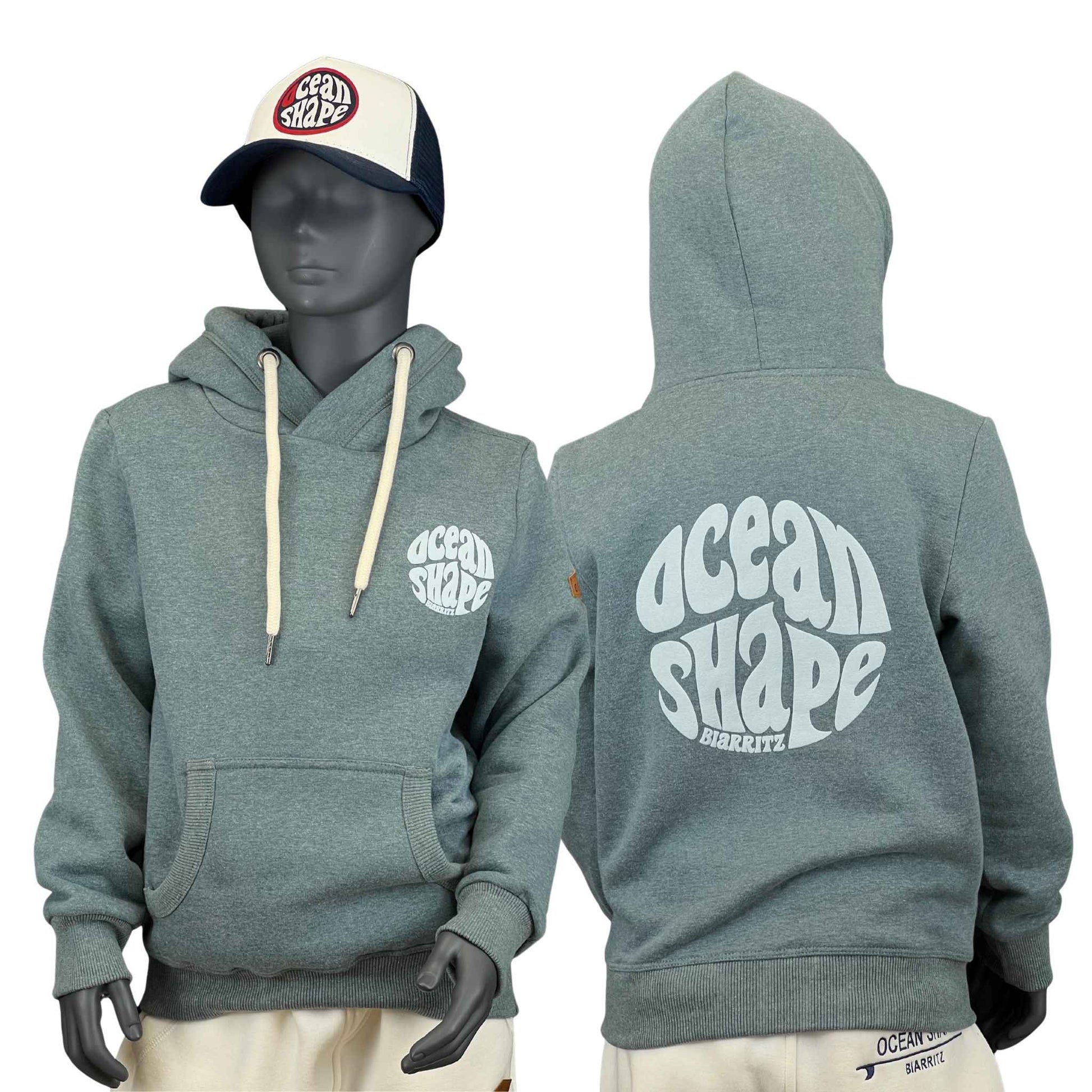 sweat à capuche unisexe enfant de couleur émeraude, vu sur un mannequin enfant de face et de dos.
Devant : logo ocean shape Biarritz en bubble en relief et une poche kangourou.
Dos : logo bubble ocean shape biarritz en relief et en grand dans le dos.
Le mannequin porte également une casquette.