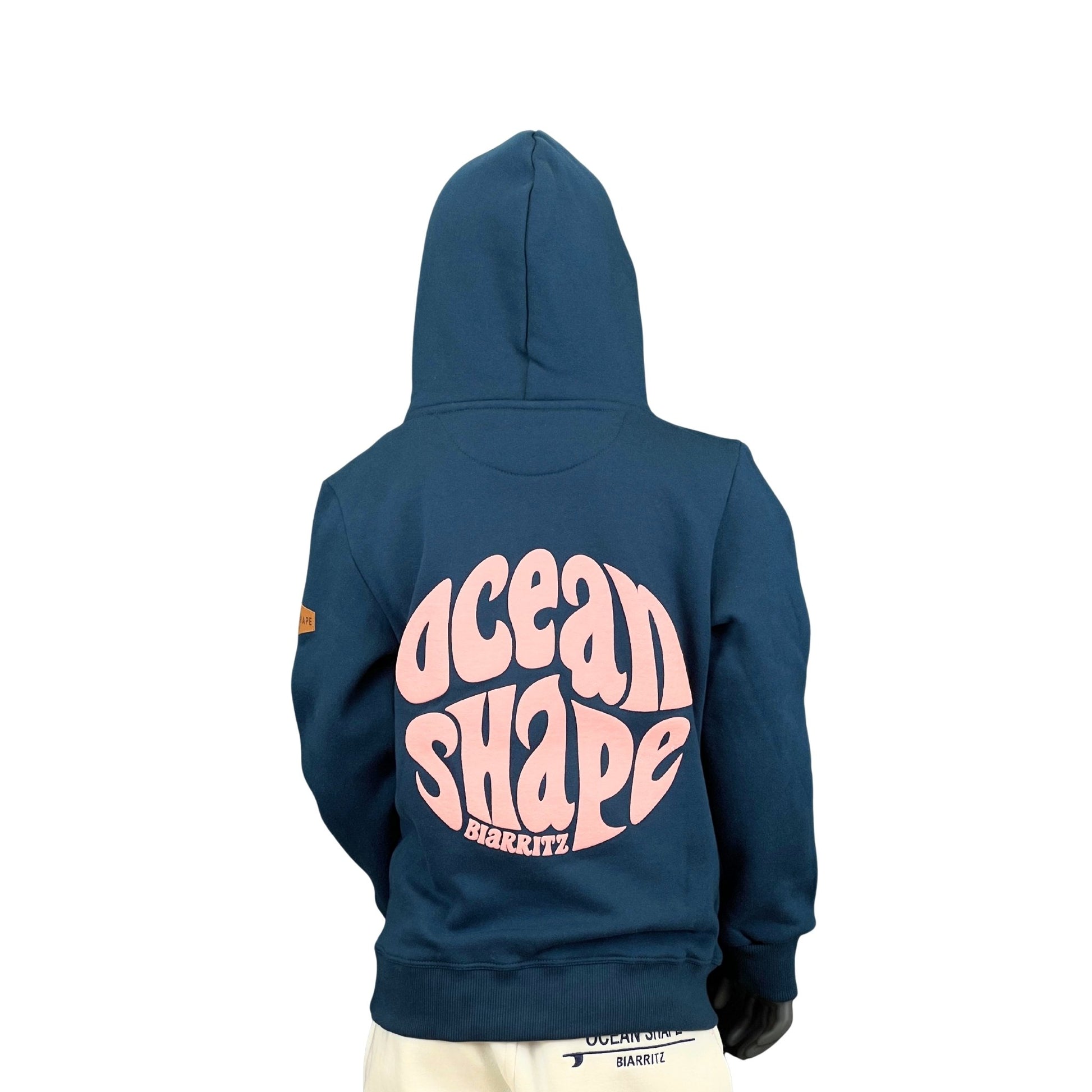 sweat à capuche unisexe enfant de couleur bleu peacock et rose pâle en coton biologique, sur un mannequin enfant de dos.
Dos : grand logo au milieu du dos.