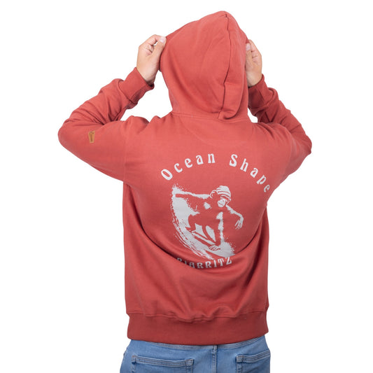 Sweat unisexe à capuche terracotta avec grand dessin de singe qui surf + écriture "Ocean Shape Biarritz" beige dans le dos, vu de dos sur mannequin homme