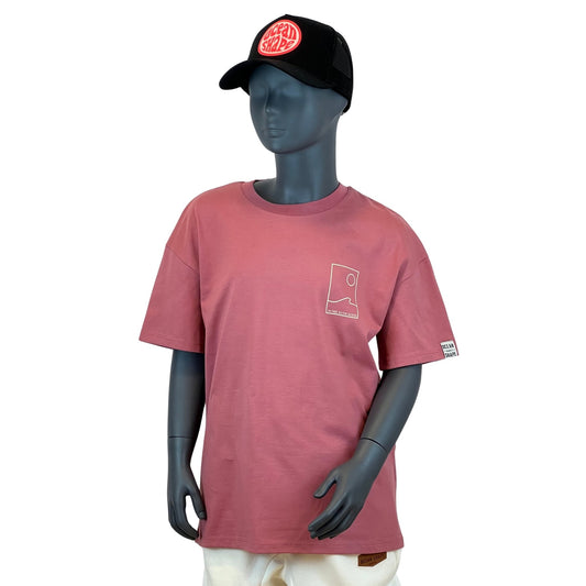 t shirt à manches courtes enfant unisexe couleur anthique rose, en coton biologique, sur un mannequin enfant de face.
Devant : dessin minimaliste d'une vague et d'un soleil avec écriture "as free as the ocean".
Le mannequin porte une casquette suédé noir ocean shape