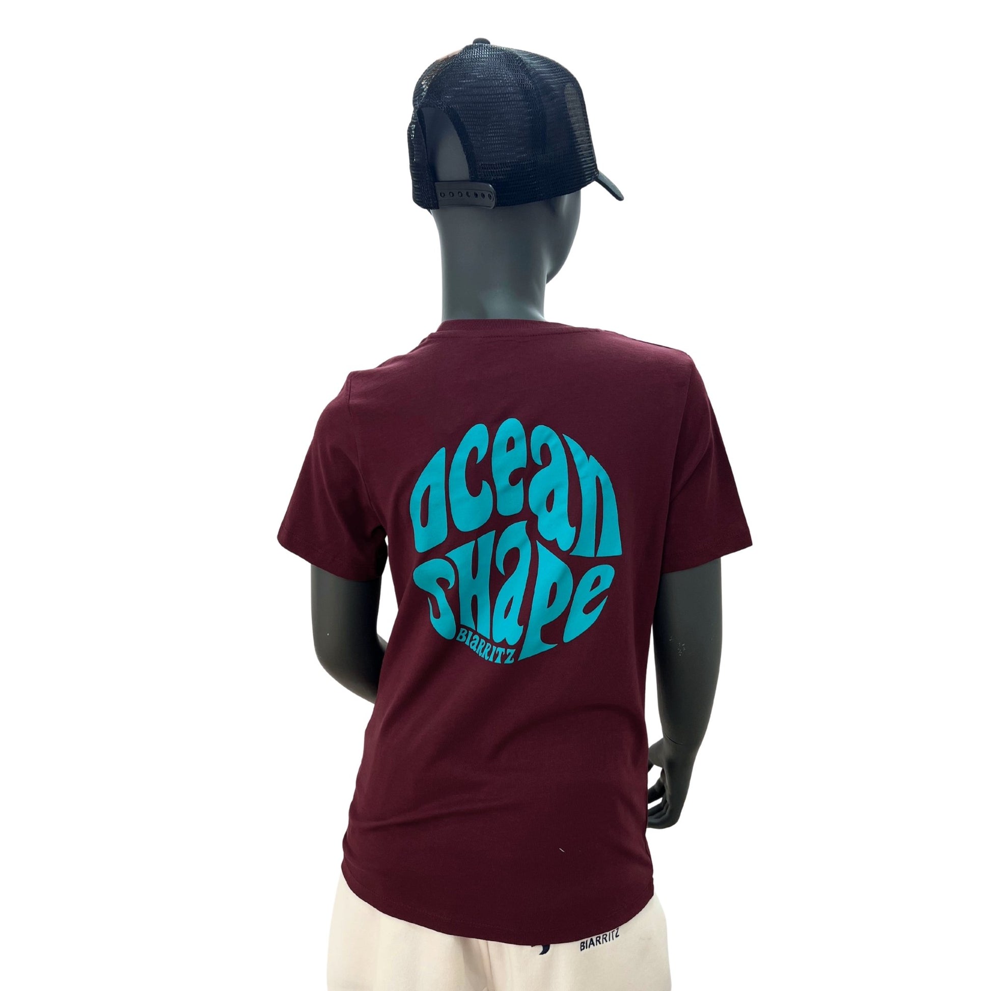 tshirt enfant à manches courtes unisexe ocean shape couleur cherry, 100% coton biologique. 
Vue de dos sur un mannequin enfant.
Gros logo bubble ocean shape couleur turquoise avec écriture "biarritz" dans le dos.