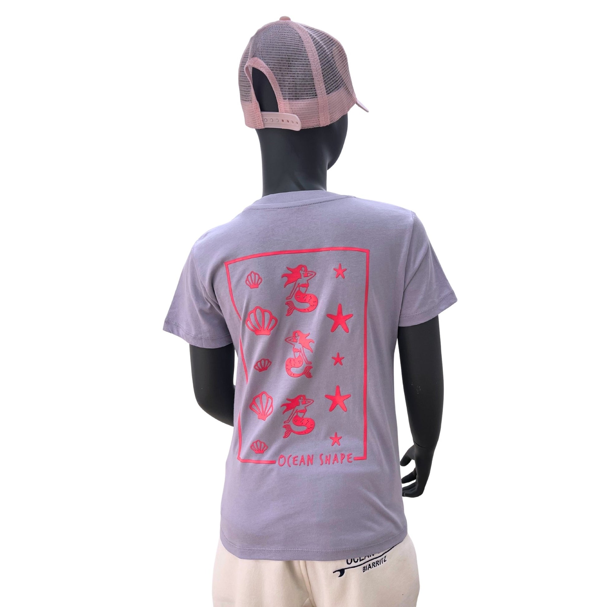 t shirt enfant en coton biologique et polyester reclyclé de couleur lavande et rose fluo, de la marque ocean shape. vue sur un mannequin enfant de face et de dos.
Dos : grand encadré avec illustrations de coquillages et sirènes en rose fluo avec logo ocean shape en bas.