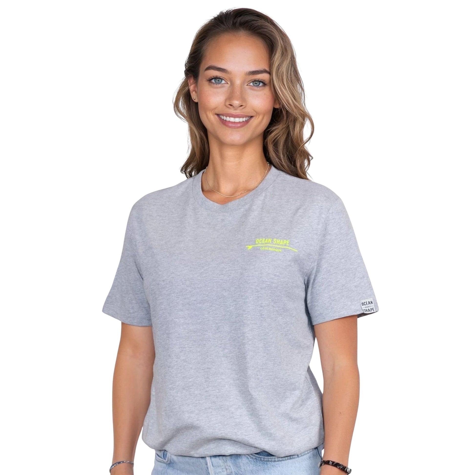 Tee-shirt unisexe gris clair en coton biologique avec petite écriture "ocean shape" jaune fluo sur la poitrine gauche, vu de face sur mannequin femme