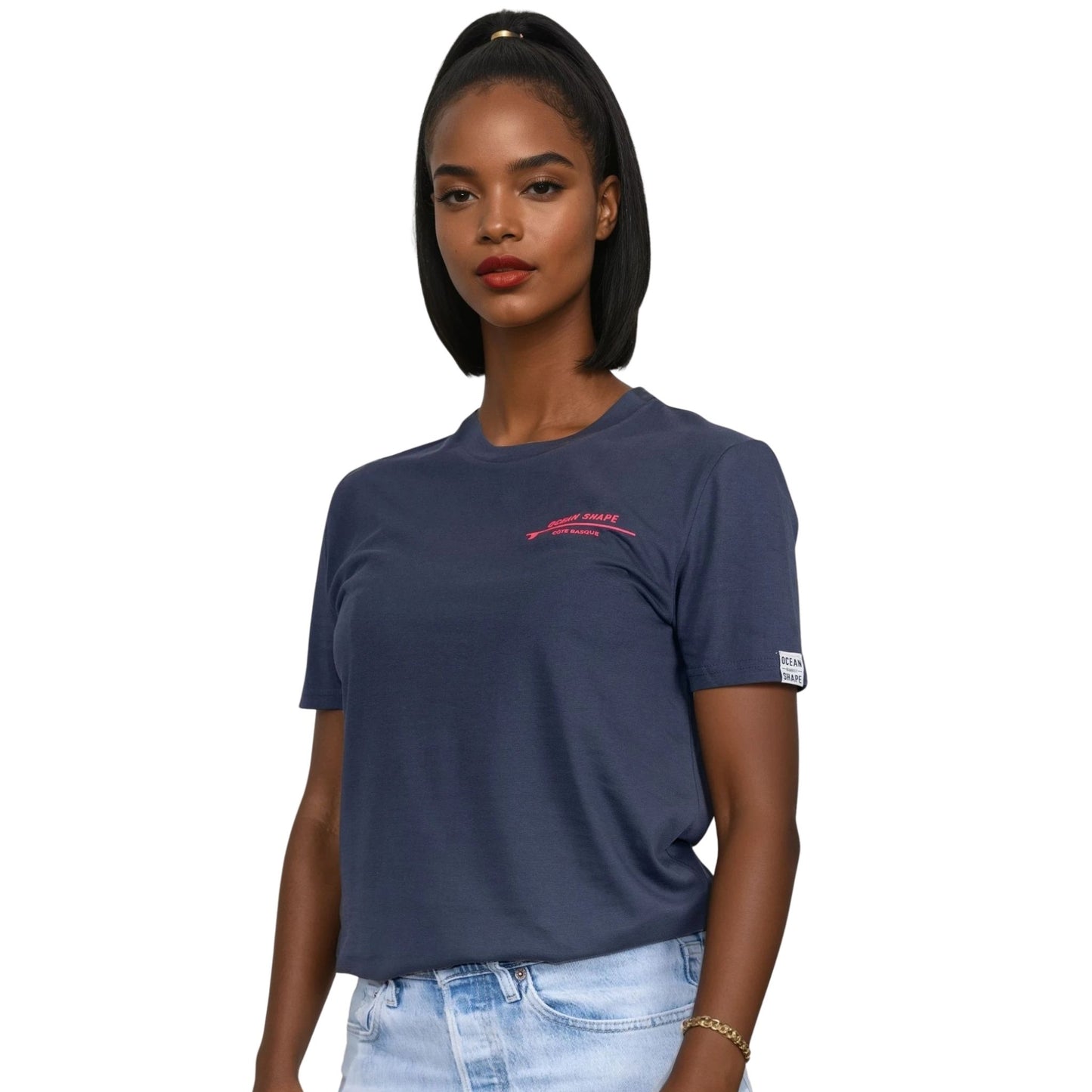 Tee-shirt unisexe gris foncé en coton biologique avec petite écriture "ocean shape" rose fluo sur la poitrine gauche, vu de face sur mannequin femme