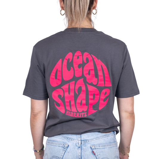 Tee-shirt gris foncé en coton biologique avec grand logo bubble ocean shape Biarritz rose fluo en haut du dos, vu de dos sur mannequin femme