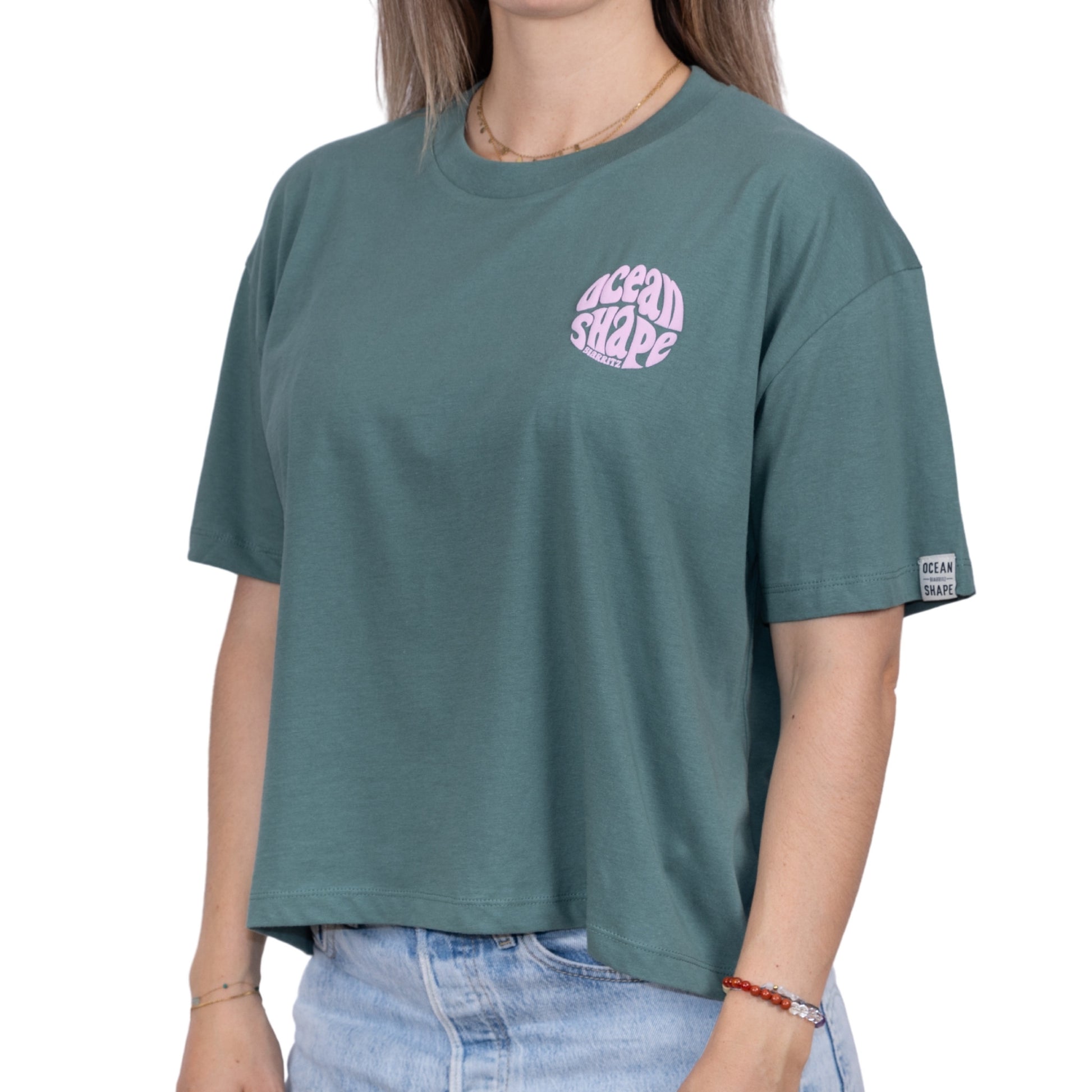 Tee-shirt femme en coton biologique couleur sauge avec petit logo bubble ocean shape Biarritz rose pastel sur la poitrine vu de face sur mannequin femme