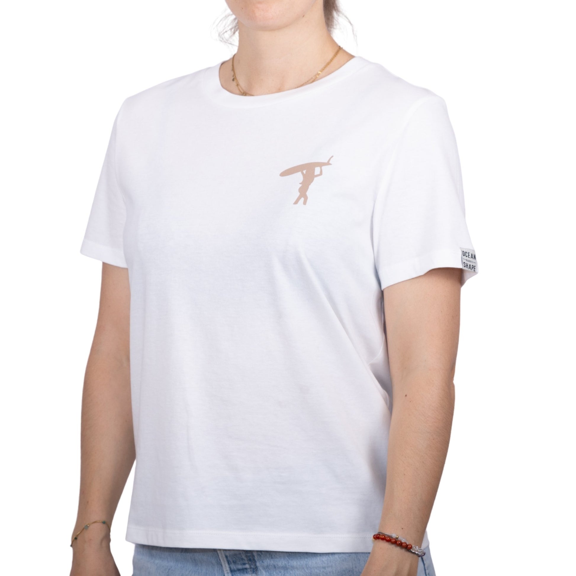 Tee-shirt femme en coton biologique blanc avec petit dessin de surfeuse qui marche de dos en beige sur la poitrine , vu de face sur mannequin femme