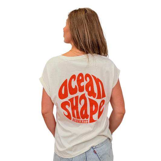Tee-shirt femme 100 % coton biologique ivoire avec gros logo bubble ocean shape orange fluo dans le dos, vu de dos sur mannequin femme