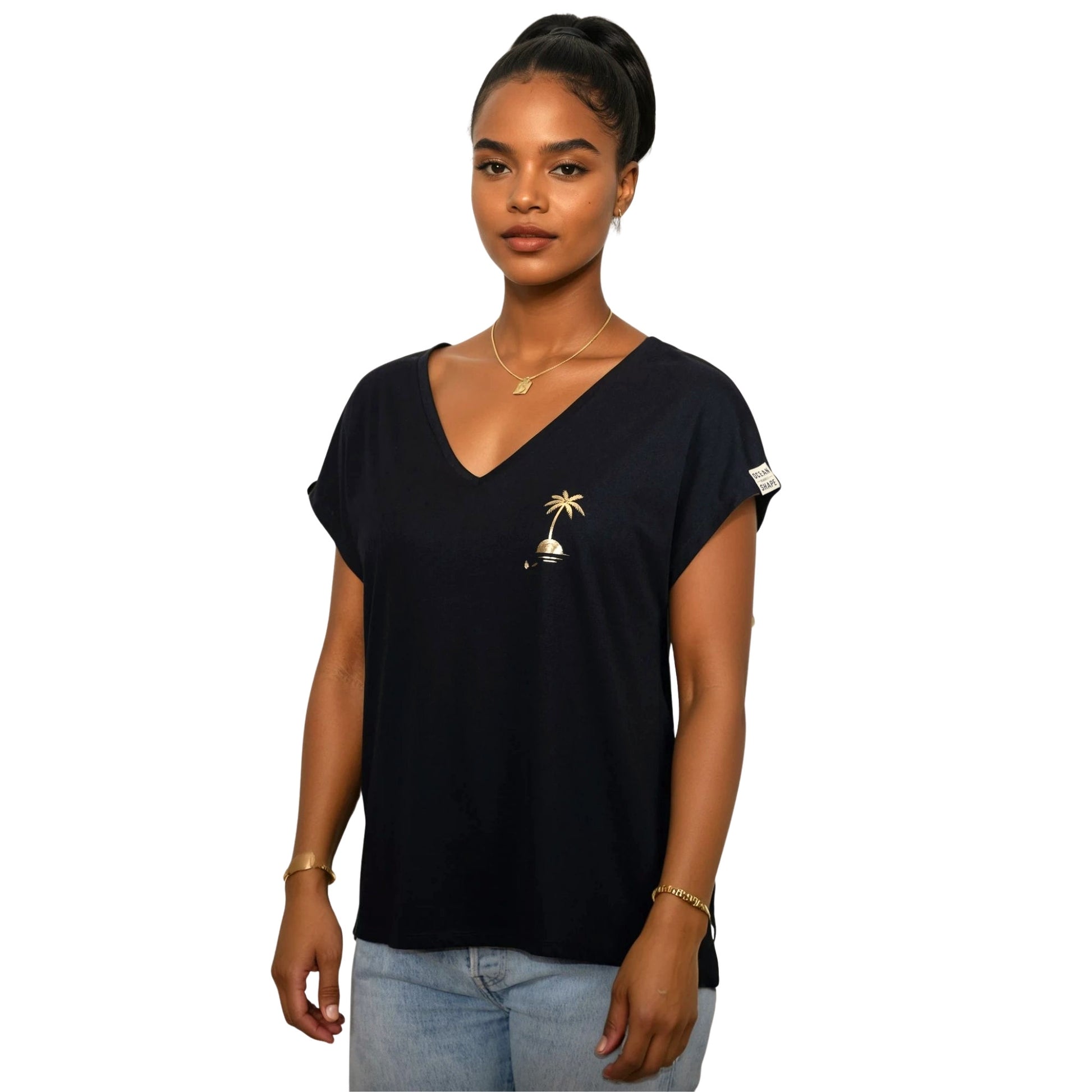 Tee-shirt femme en coton biologique noir avec petit dessin palmier sur île couleur doré sur la poitrine, vu de face sur mannequin femme 
