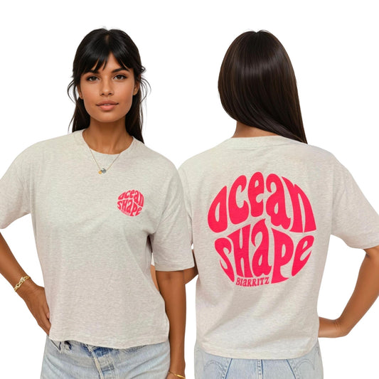 T-shirt femme en coton biologique gris, vu de face et de dos sur mannequin femme.
Devant : petit logo bubble "ocean shape biarritz" rose fluo sur la poitrine gauche.
Dos : gros logo bubble "ocean shape biarritz" rose fluo.