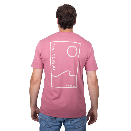 Tee-shirt unisexe rose foncé en coton biologique avec grand vague / soleil minimaliste et écriture "ocean shape Biarritz" beige dans le dos, vu de dos sur mannequin homme