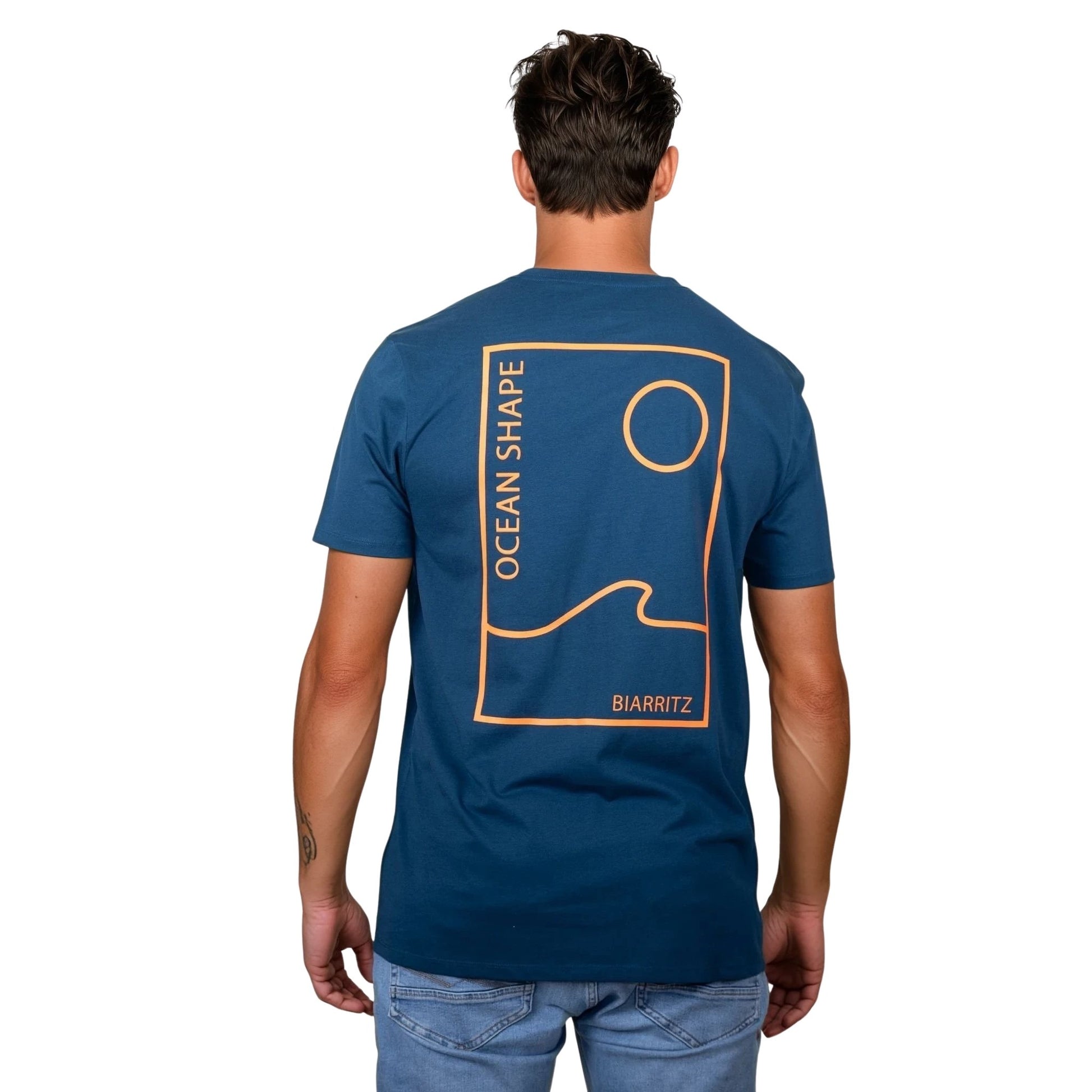 Tee-shirt unisexe bleu petrole en coton biologique avec grand encadré vague / soleil minimaliste + écriture "ocean shape Biarritz" orange fluo dans le dos, vu de dos sur mannequin homme.