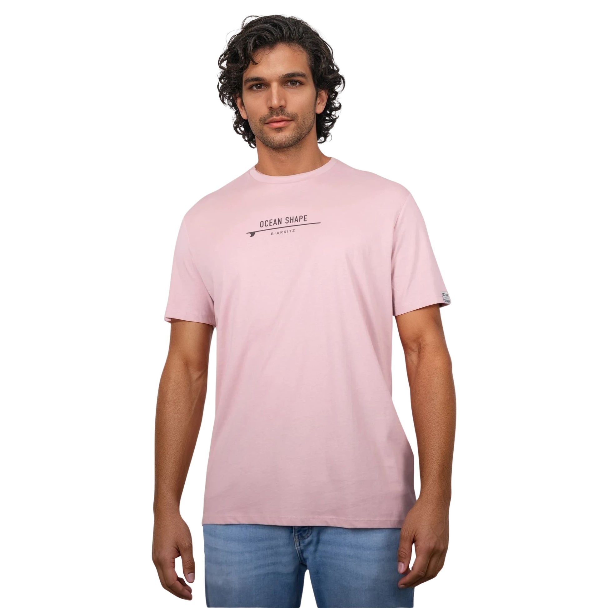 Tee-shirt unisexe rose pale en coton biologique avec petite signature "ocean shape Biarritz" sur surf marron foncé sur la poitrine, vu de face sur mannequin homme